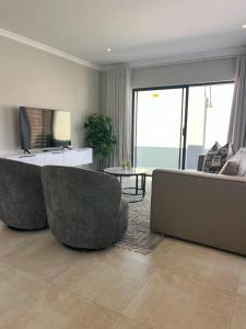 a living room with two chairs and a couch at Zahari Villas in Parys