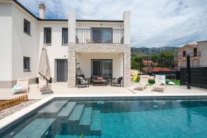 a swimming pool in front of a house at Villa Ginger Modern Villa with Private Pool in Omiš