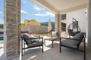 a patio with two chairs and a table at Villa Ginger Modern Villa with Private Pool in Omiš