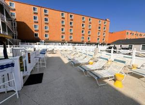 a row of lounge chairs in front of a building at Oceanic Hotel in Wildwood