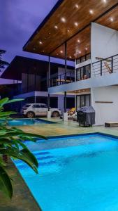 a house with a swimming pool in front of a house at Samara by the River Vacation Suites in Sámara +10 photos