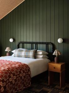 a bedroom with a bed with green walls and two lamps at The Alpine House in Jackson +20 photos