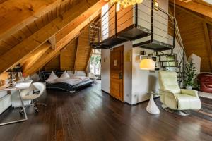 an attic living room with a staircase and chairs at Hotel-Restaurant Eifeler Seehütte in Rieden