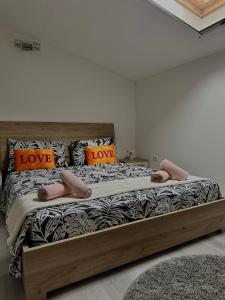 a bedroom with a large bed with love pillows at Deluxe apartment 2 rooms , near Koper and Trieste in Plavje