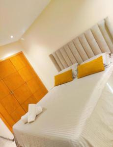 a bedroom with a large white bed with yellow pillows at Peninsula promenade in Tamaris +4 photos