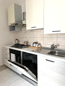 a kitchen with white cabinets and a dishwasher at Deluxe apartment 2 rooms , near Koper and Trieste in Plavje