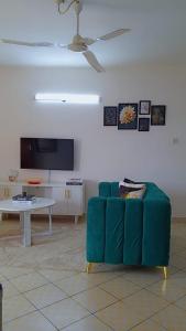 a living room with a green couch and a table at tabby stays one bedroom with two beds bamburi in Mombasa +4 photos