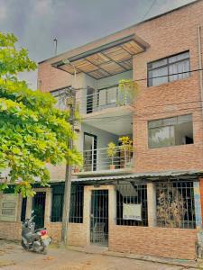a brick building with a balcony on top of it at Casa Vacanza Apartamentos in Leticia
