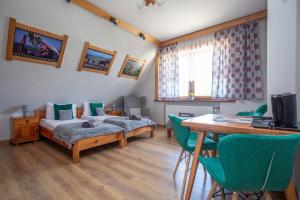 a room with two beds and a table and chairs at U Studniara in Murzasichle
