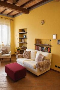 ein Wohnzimmer mit einem weißen Sofa und einem roten Hocker in der Unterkunft Simona's house in Montaione + 3 Fotos