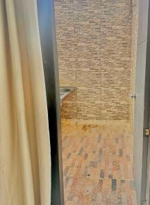 a bathroom with a shower with a brick wall at Casa Vacanza Apartamentos in Leticia +10 photos