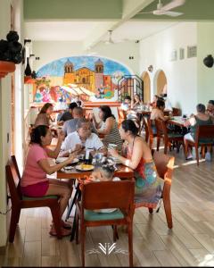 a group of people sitting at tables in a restaurant at Casa Danna Huatulco in Santa Cruz Huatulco