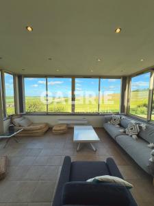 a living room with couches and a table and windows at GC - Villa L'Idéal - Vue Mer in Hervelinghen