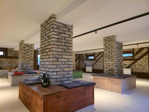 a large room with brick columns and a table at Imanje Dorf in Ravno Selo