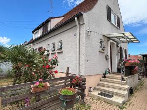 a white house with a wooden fence and flowers at Chez Tiina in Colmar