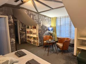 a bedroom with a desk and two chairs and a table at Ateliér Kráľovič in Hokovce