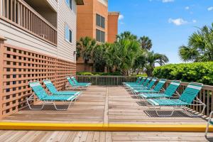 a row of blue lounge chairs on a deck at Ocean Forest Colony in Myrtle Beach