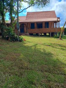 a house with a deck and a grass yard at Frida's Haus in Nova Petrópolis