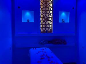 a blue room with a table and a mirror at Bungalow 2 chambres salon in Ngaring