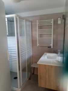 a bathroom with a sink and a glass shower at petite maison Bellevue in La Celle-sous-Gouzon