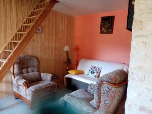 a bedroom with a bed and a chair and a staircase at petite maison Bellevue in La Celle-sous-Gouzon