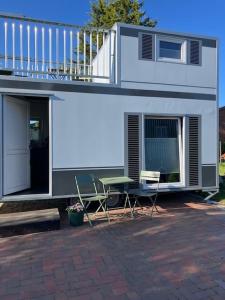 a house with a balcony and a table and chairs at Reetblick in Haseldorf