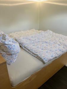 an unmade bed with a blanket on top of it at Reetblick in Haseldorf