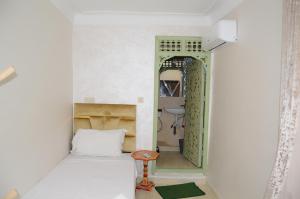 a small room with a bed and a stool in it at Riad Dar Lokman in Marrakesh