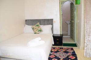 a bedroom with a white bed with a mirror at Riad Dar Lokman in Marrakesh +105 photos