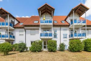 an apartment building with blue balconies and orange roofs at Casa Materi Geldersheim in Geldersheim