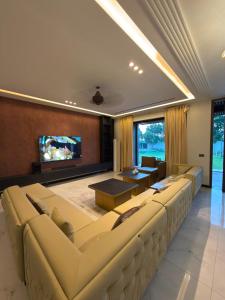 a living room with a large couch and a tv at SA Farms in Lahore