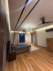 a bedroom with a bed on a wooden floor at SA Farms in Lahore