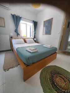 a bedroom with a large bed with blue sheets and a rug at Manolia Home in Parikia