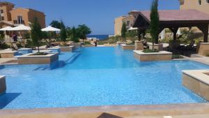 a large pool with blue water in a resort at Chalet in Sahel Mountain view Diplo in Ras Elhekma