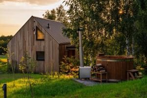 a wooden shed with a hot tub next to a tree at Cztery Widoki Luksusowe Domki Góry Świętokrzyskie in Huta Szklana