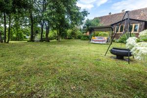 a yard with a tire swing and a house at Pod lasem in Górowo Iławeckie
