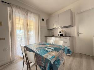 a kitchen with a table with chairs and a tablecloth on it at M473 - Marcelli, trilocale con posto auto e wifi in Marcelli