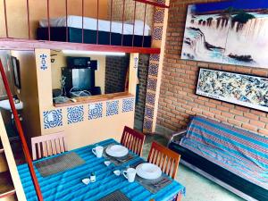 a table and chairs in a room with a bunk bed at Mar en Casa - Taganga - Vista al Mar in Taganga
