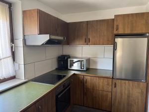 a kitchen with wooden cabinets and a stainless steel refrigerator at Ferienhaus Tal in Geislingen