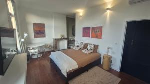 a bedroom with a bed and a table in it at Hi bed & breakfast Liège in Liège