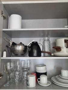 a kitchen shelf with dishes and a tea pot at Céu Sol Sul in Porto Alegre