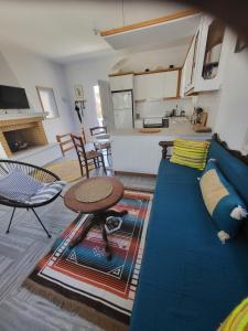 a living room with a blue couch and a table at Manolia Home in Parikia