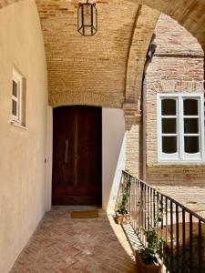 an entrance to a building with a wooden door at Dimora Palazzo De Luca - Intra Alborgodiffuso - Loft di Charme del 700 con Vasca doppia e Camino in Serracapriola