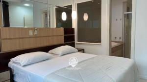 a bedroom with a large bed with two pillows at Apartamento Almeida e Moraes 3 Suítes com Hidro in Itapema