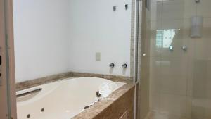 a bathroom with a bath tub and a shower at Apartamento Almeida e Moraes 3 Suítes com Hidro in Itapema +21 photos