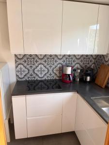 a kitchen with white cabinets and a stove top oven at Ferienwohnung Talglück in Weissach Im Tal