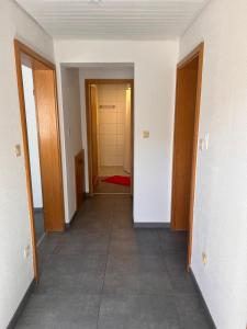 an empty hallway with two doors and a tile floor at Ferienwohnung Talglück in Weissach Im Tal