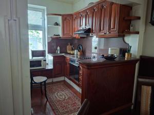 a kitchen with wooden cabinets and a stove at Ace Apartments in Bitola +14 photos