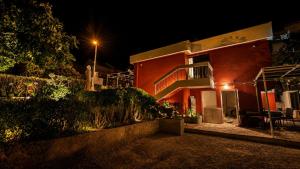 a red building with a balcony at night at Polaroid House '76 in Radovici