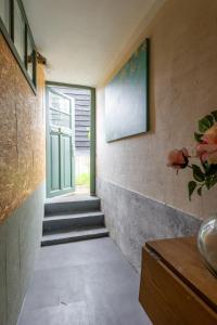 a hallway with a door and a vase of flowers at Appartement de Tuinkamer in Kampen